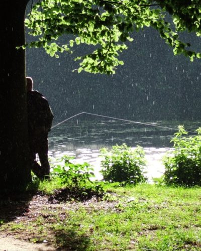 Ein Angler steht mit dem Rücken am Heitkampsee in Geldern