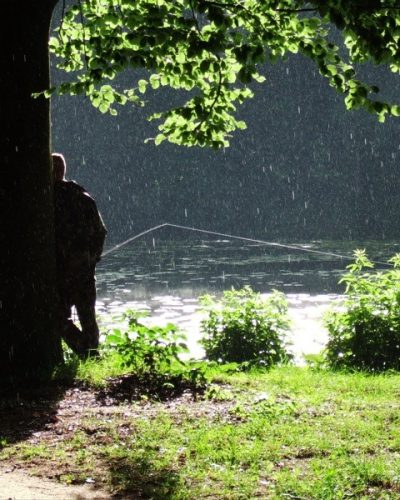 Ein Angler steht mit dem Rücken am Heitkampsee in Geldern